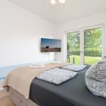 Bedroom with bed, TV, and glass door to the garden.