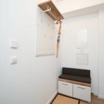 Entrance with bench, shelf, and wall cabinet. Wall art shows beach.