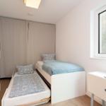 A bedroom with a bed and a sleeping space. There is a window and a wardrobe.
