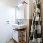 Bathroom with sink, mirror cabinet, and shower curtain.