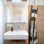 Bathroom with sink, mirror, and shower curtain.
