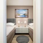 Two beds with nightstand and wall mural of a beach.