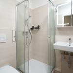 Modern bathroom with shower, sink, and toilet.