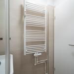 Bathroom with heater, mirror, and shower