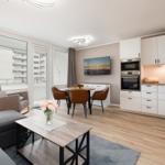 Living and dining area with modern kitchen and large window view.