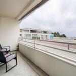 Balcony with two chairs and view of the beach and sea.