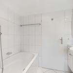 Badezimmer mit Badewanne, Dusche, Waschbecken und Spiegelschrank.
