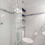 Badezimmer mit Dusche, Toilette und Waschbecken.