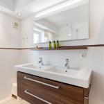 Bathroom with double sink, mirror cabinet, and window