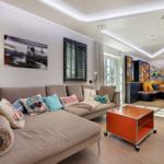 Wohnzimmer mit Sofa, orangefarbenem Tisch und Kamin