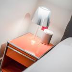 Schlafzimmer mit Nachttisch, Lampe und Lautsprecher
