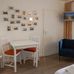 Ein Zimmer mit Tisch, Stühlen, Sofa und Fernseher an der Wand.