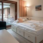Schlafzimmer mit Doppelbett, Balkon und Wandbildern