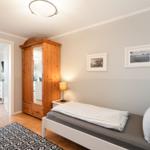 Bedroom with bed, wardrobe, and pictures on the wall.