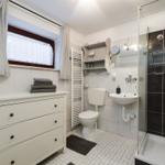 Bathroom with shower, sink, toilet, and washing machine.