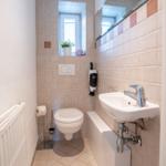 Bathroom with toilet, sink, and window