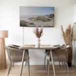 Dining area with table, chairs, and TV mounted on the wall.