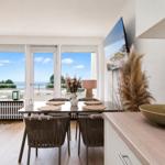 Dining area with table, chairs, and view of the beach.