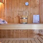 Sauna mit Holzbank, Eimer, Thermometer und Handtuch