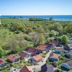 Dorf mit Häusern, Wald und Leuchtturm am Meer