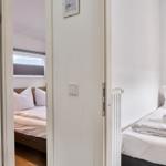 Zwei Schlafzimmer mit Betten und Fenstern. Ein Raum hat einen Heizkörper.