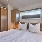 Schlafzimmer mit Doppelbett, Holzmöbeln und Fenster mit Blick.