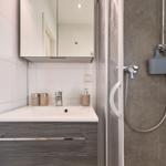 Badezimmer mit Waschbecken, Spiegel und Dusche