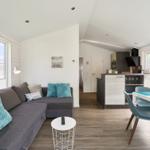 Wohnzimmer mit Sofa, Esstisch und Küchenbereich