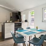 Essbereich mit Tisch und Stühlen, Küchenzeile und Blick in Schlafzimmer