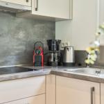 Küche mit Induktionskochfeld, Kaffeemaschine und Wasserkocher.
