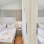 Zwei Schlafzimmer mit jeweils einem Bett und Schrank über dem Bett.