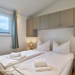 Schlafzimmer mit Doppelbett, Nachttischen und Fenster mit Blick.