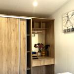 Schlafzimmer mit Holzschrank, Spiegelfläche und Wandbild