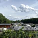Terrasse mit Blick auf Wohnanlage und Wald unter bewölktem Himmel.