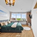 Schlafzimmer mit Bett, Fenster und Wandregalen.