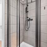 Duschkabine mit Glaswand und Duschkopf an der Wand
