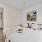 Schlafzimmer mit Bett, Wandbild und Blick in angrenzende Räume.