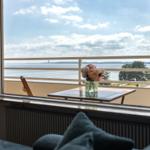 Blick aufs Wasser vom Balkon mit Tisch und Blumen