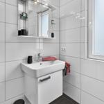 Badezimmer mit Waschbecken, Spiegelschrank und Fenster