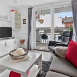 Wohnzimmer mit Sofa, Couchtisch und Balkon. Fernseher und Schrank sind vorhanden.