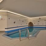 Innenpool mit Wandfliesen und Metalltreppe