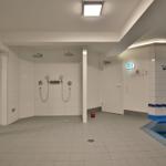 Indirekter Blick auf die Dusche und den Poolbereich mit blauem Rand.