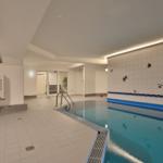 Innere Schwimmhalle mit blauem Wasser und dekorierten Wänden.