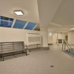 Innenpool mit Sitzbank, Pflanze und Dachfenstern. Hintergrund: Dusche und Tür.