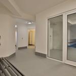 Hallenbad mit Dusche und Pflanze im Flur