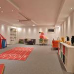 Kinderzimmer mit Spielbereich, Zelt, Matte und Stauraum. Spielzeug und Möbel sind sichtbar.
