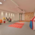Kinderzimmer mit Kletterwand, Zelt und Spielmatte.