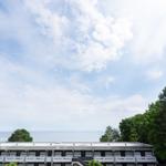 Haus mit Blick auf See und Himmel mit Wolken und Bäumen.