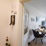 Eingangsbereich mit Schlüsselhalter und Blick in Esszimmer mit Tisch und Stühlen.