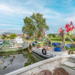 Bootshafen mit mehreren Booten und roten Flaggen am Ufer.